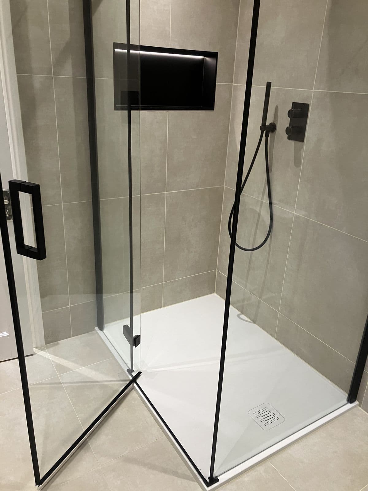Wall-mounted mirrored bathroom cabinet with integrated light and shaver socket above a round-basin vanity unit